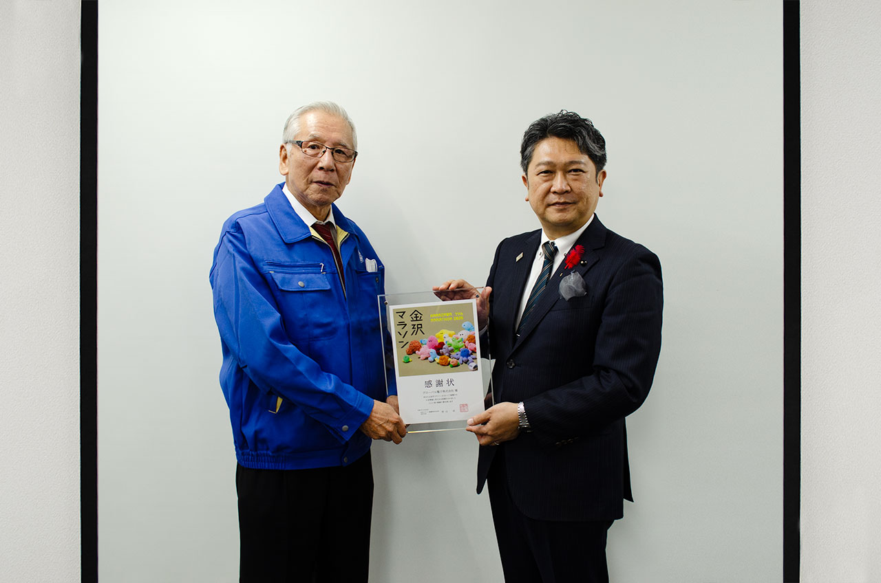 弊社松田会長（左）と村山金沢市長（右）